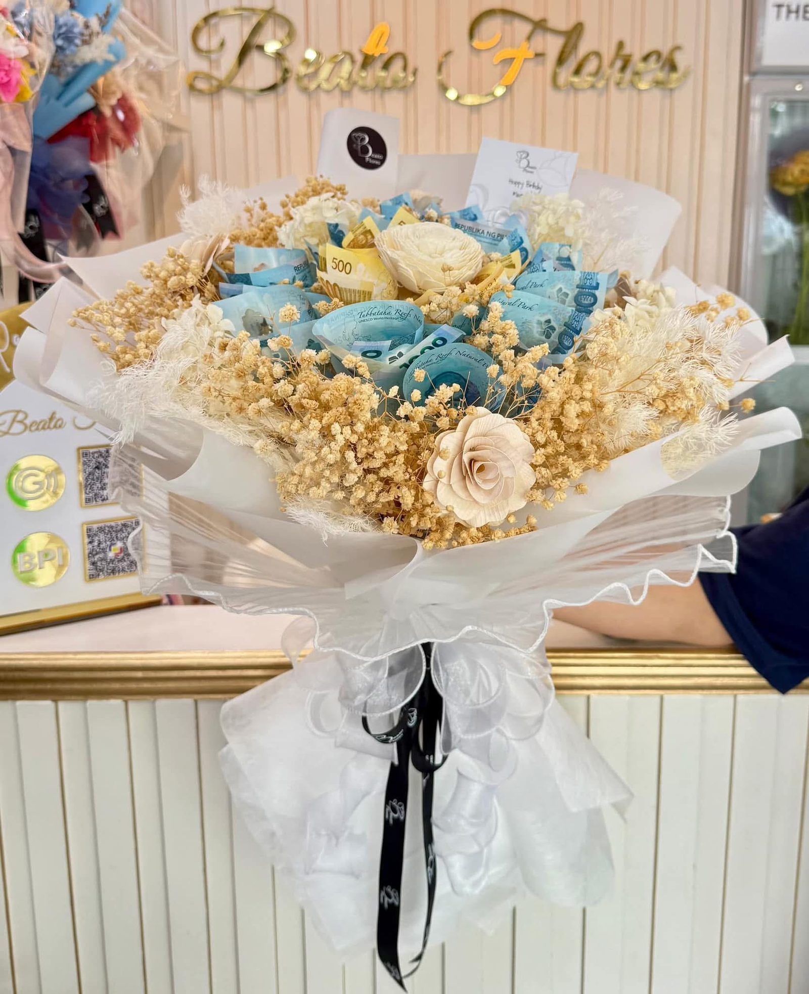 White and gold money bouquet with peso bills